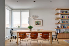 05 The dining space features a wooden table and orange wooden chairs