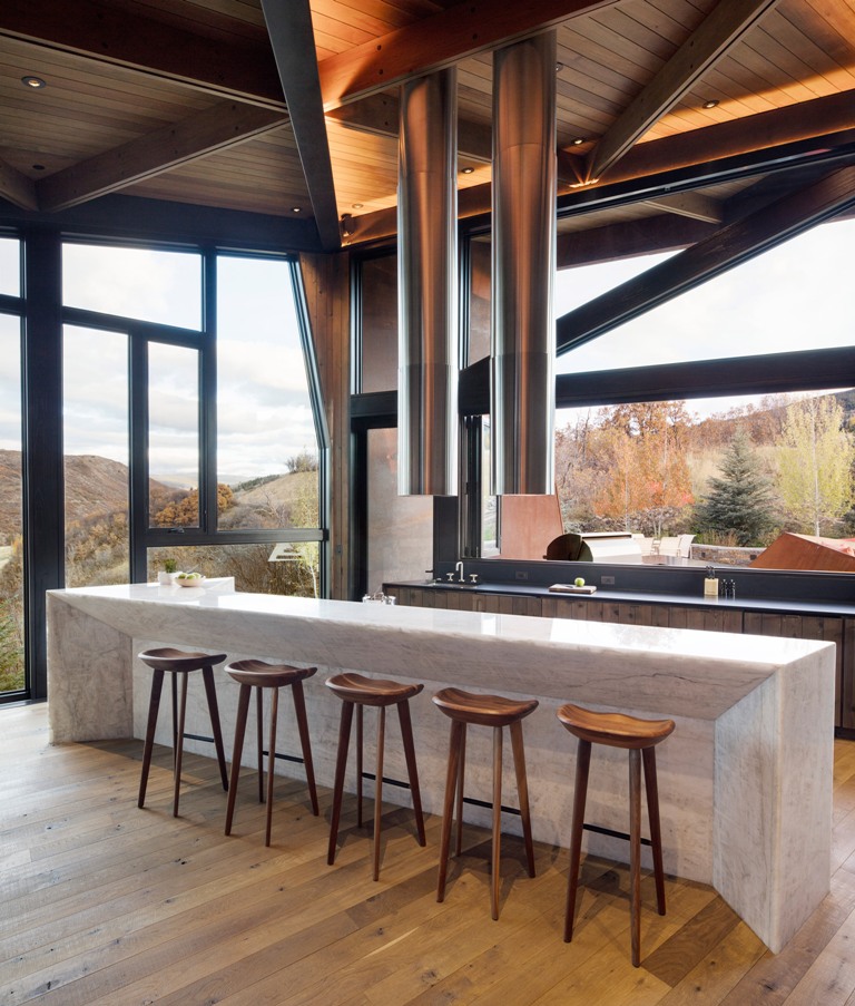 The kitchen features full glazing to catch the views, a stone kitchen island and a modern tube hood