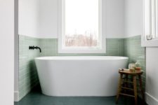 05 a contemporary bathroom with a bathtub niche covered with green tiles that match dark green floors