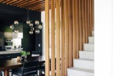 05 a dining space wraped in a vertical wooden plank screen on one side and from above that makes it a design feature