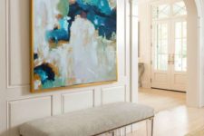 05 a modern bench with acrylic legs, creamy upholstery and an abstract artwork with creamy shades