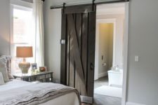 05 a vintage-inspired farmhouse bedroom with a dark stained sliding barn door to stand out