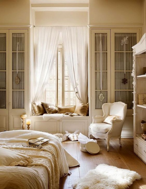 a warm and refined French country chic bedroom with a window seat