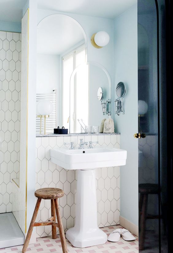 an accent and a task light with layered mirrors in a modern art deco bathroom