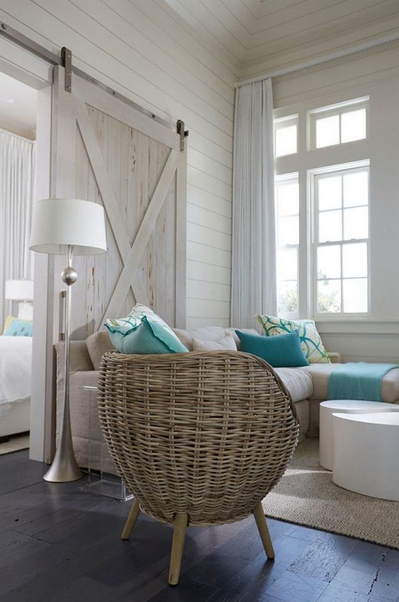 a whitewashed barn door is a part of decor and perfectly matches a coastal space