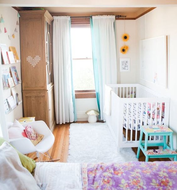a colorful master bedroom with a corner given to the baby - bookshelves, a wardrobe and a crib with steps