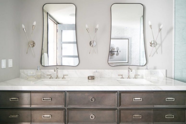 You may see a large double vanity, eye-catchy shaped mirrors and creative wall lamps