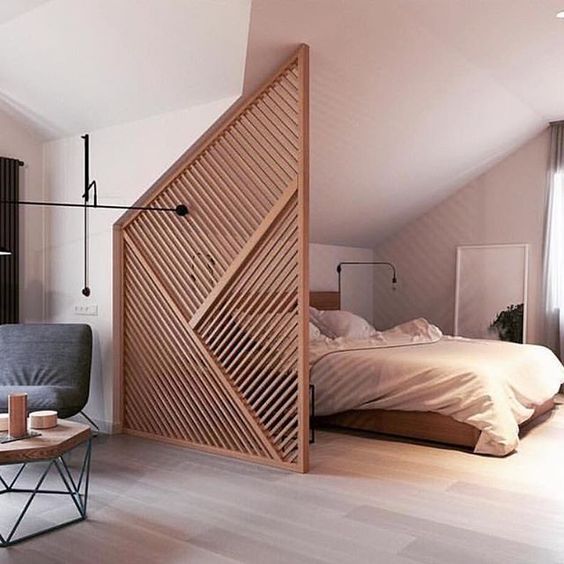 a geometric wooden screen that highlights the attic ceiling of the bedroom