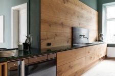 09 a modern kitchen with sleek walnut cabinets and a backsplash and dark green walls