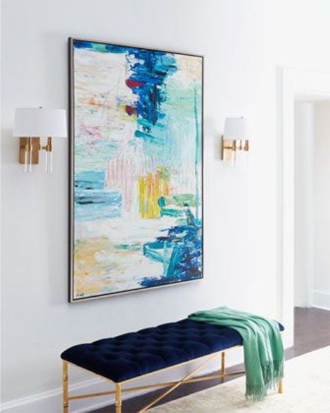 an oversized bright watercolor brushstroke artwork and a matching navy and copper upholstered bench