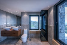 10 The master bathroom is done with concrete, stone-like tiles and wooden pieces to make it warmer