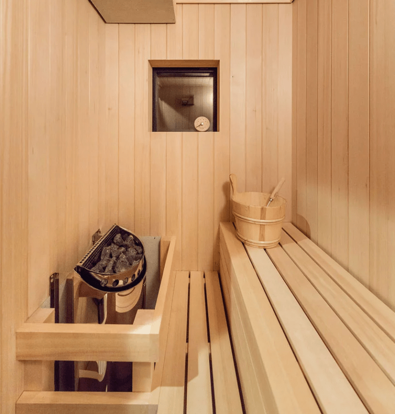 There's a sauna fully clad with light-colored wood and designed in minimalist style like the rest of the home