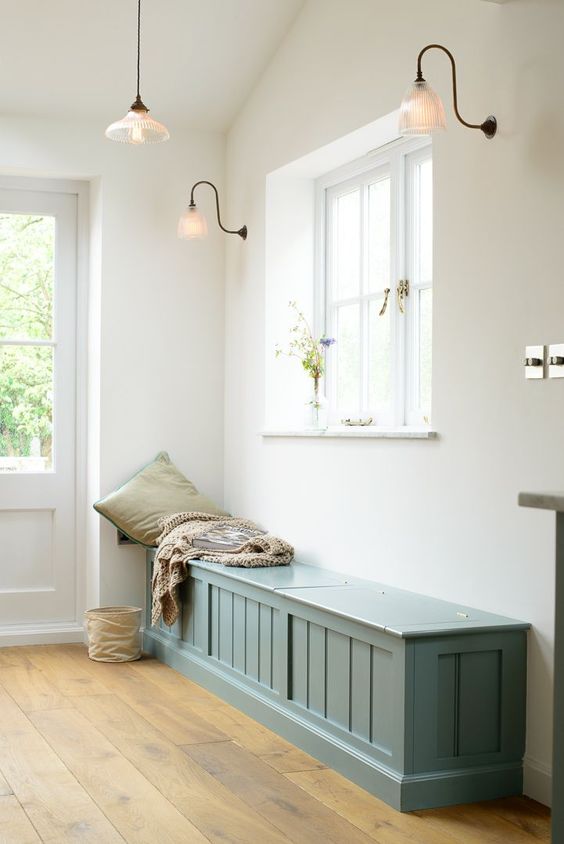 a blue farmhouse bench with much storage space inside for a vintage entryway