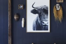 a cool navy entryway with wabi-sabi touches and a bull artwork that makes a statement