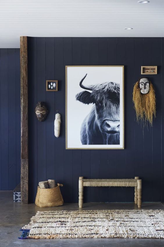 A cool navy entryway with wabi sabi touches and a bull artwork that makes a statement