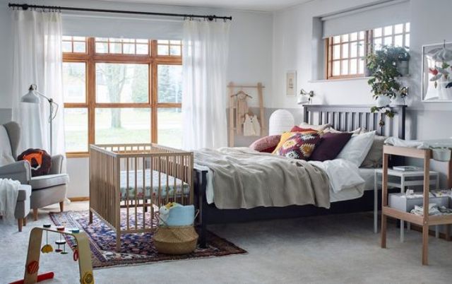 a modern bedroom decorated with IKEA furniture and a comfy crib at the bedfoot