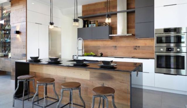 a modern space with an industrial feel and warm-colored wood on the backsplash and kitchen island