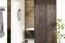 10 dark stained sliding barn door hides a small bathroom and stands out in a neutral space