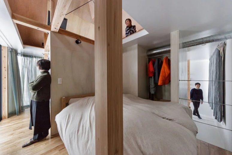 A small sleeping space and a makeshift closet are located next to the living space and can be divided with curtains