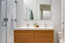 11 The bathroom is serene, with white tiles and a floating light-colored wood vanity
