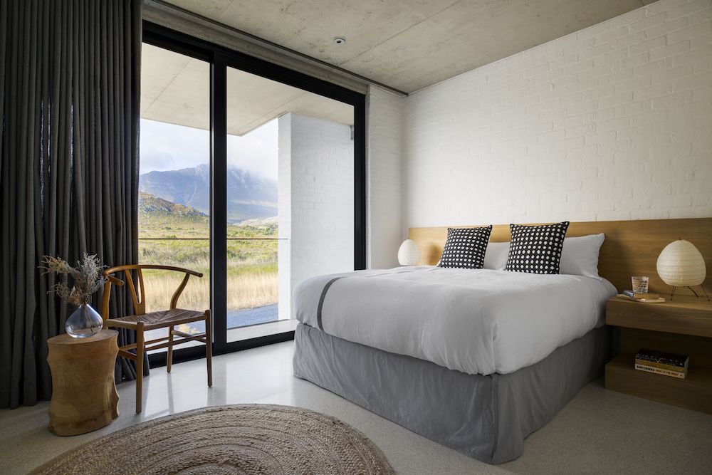The master bedroom features a tall platform bed and floating nightstands plus gorgeous views