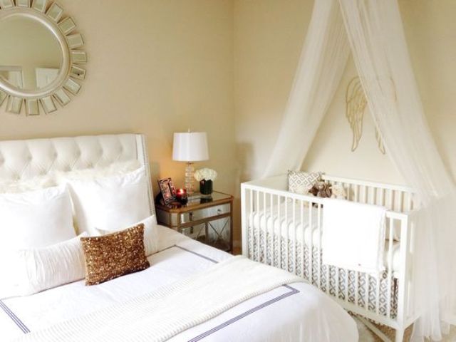 a modern glam master bedorom with a crib and a canopy by the wall - evena  small space can accomodate what you need