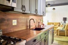 11 a navy and light blue kitchen with leather handles and a rich-colored plywood backsplash and countertop