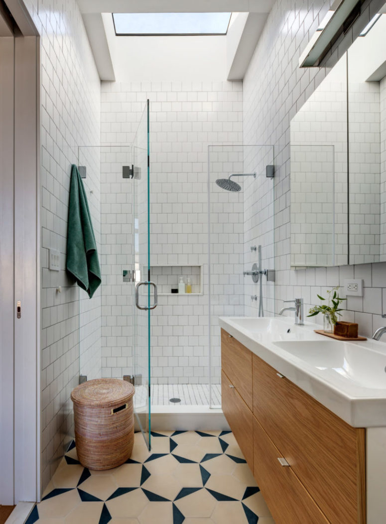 The shower space is done in white tiles with glass for a seamless look
