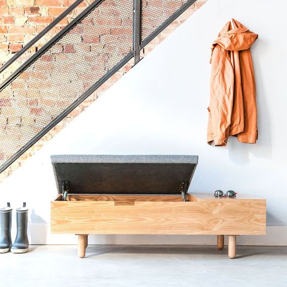 a comfy wooden storage bench with a grey seat on top and a space for accessories