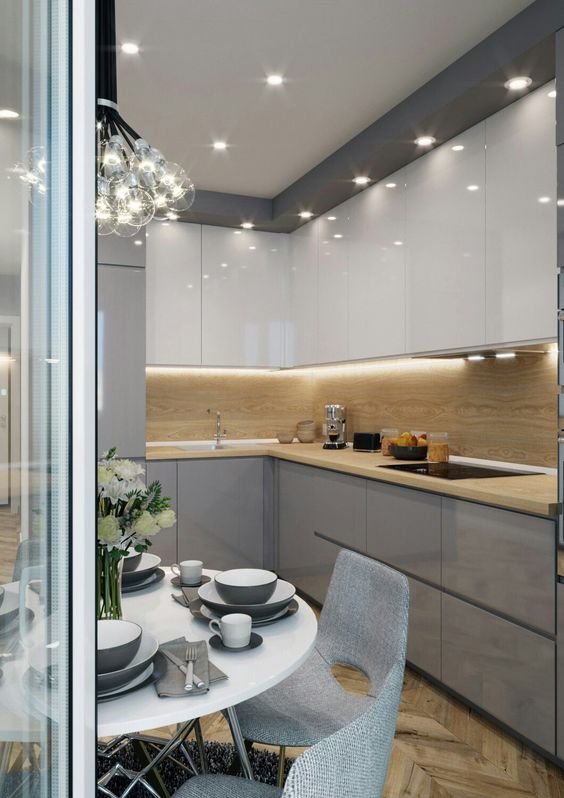A minimalist kitchen fully illuminated with a large bubble chandelier and some built in lights