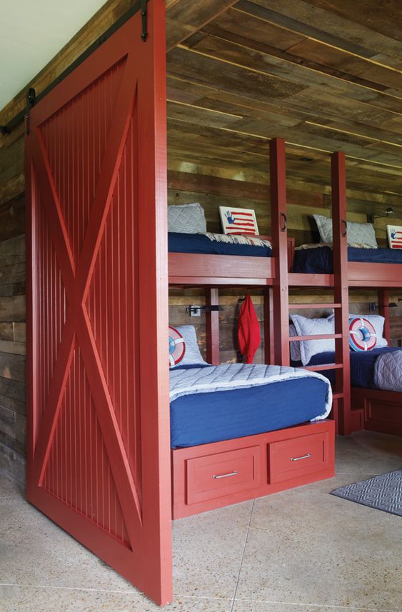 a rustic blue and red boys' bedroom and a matching red barn door to highlight the theme