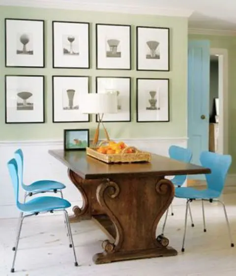 an antique table with carved legs and bold blue chairs on metal legs that highlight it