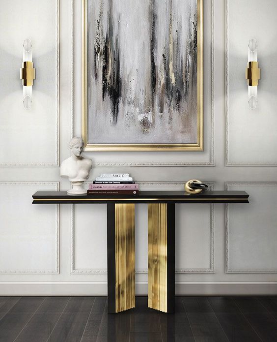 a refined black and gold console plus a matching grey, black and white artwork in a gilded frame