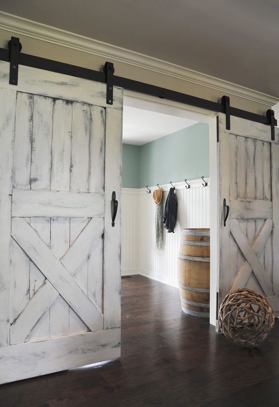 the soft whitewashed shade of the doors contrasts the exposed hardware and create a unique combo