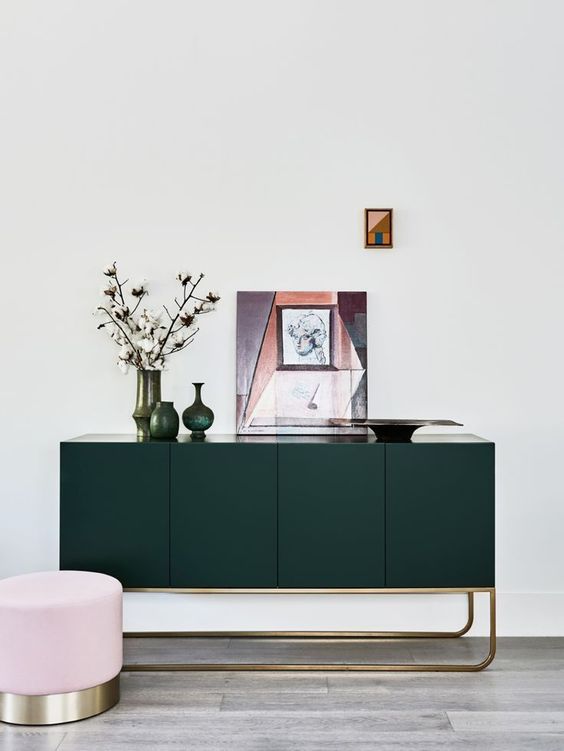 a forest green console with gilded touches is a chic and refined idea