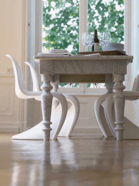 a refined dining table and white sculptural modern chairs of the same shade to make the look not so different