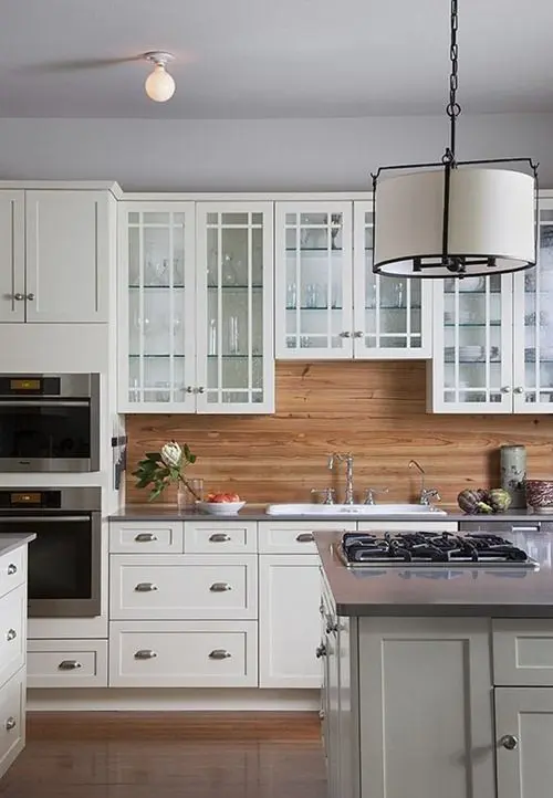 traditional white cabinets are warmed up with a light-colored wood backsplash