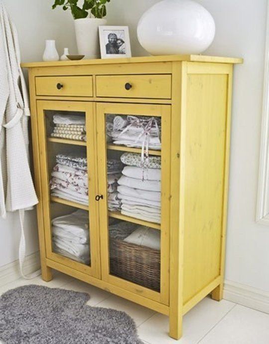 a yellow cabinet with glazing is a great idea to store towels in a rustic bathroom