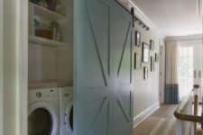 17 a large light blue barn door is used to hide a built-in laundry and keep the space neat
