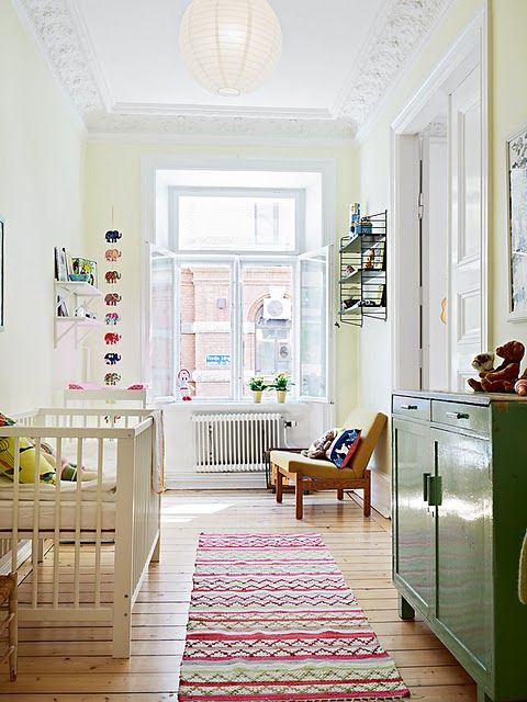 a large window and some simple paper lamps are all the you need for a comfy nursery