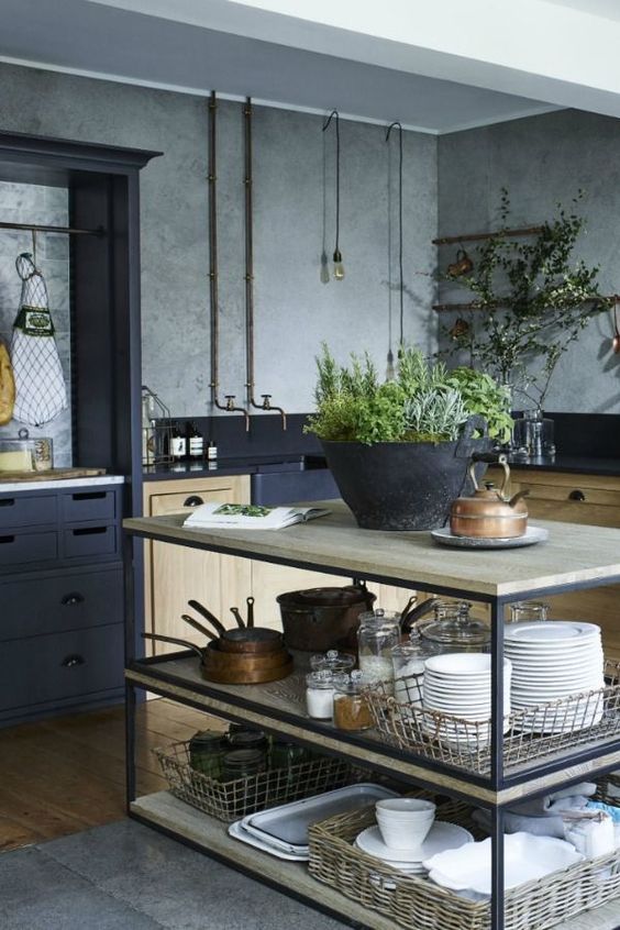 A simple industrial kitchen island with black metal framing and light colored wooden tops and shelves for storage