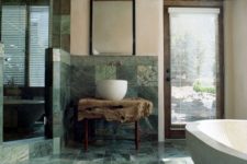 17 a stunning natural bathroom with green marble tiles, a raw wood slab vanity and wooden touches
