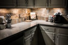 18 a rustic off-white kitchen with a stone countertop and a reclaimed wood backsplash plus additional lights