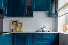 18 bold blue cabinets make a colorful statement here and raise the mood making maximum of a small space