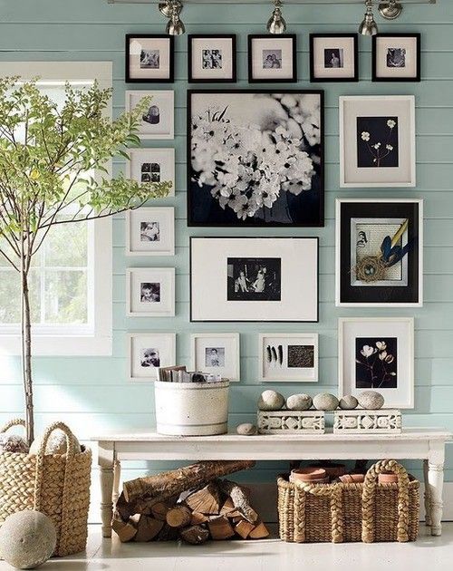 a country house entryway with mint walls, baskets and a gallery wall in black and white for a statement