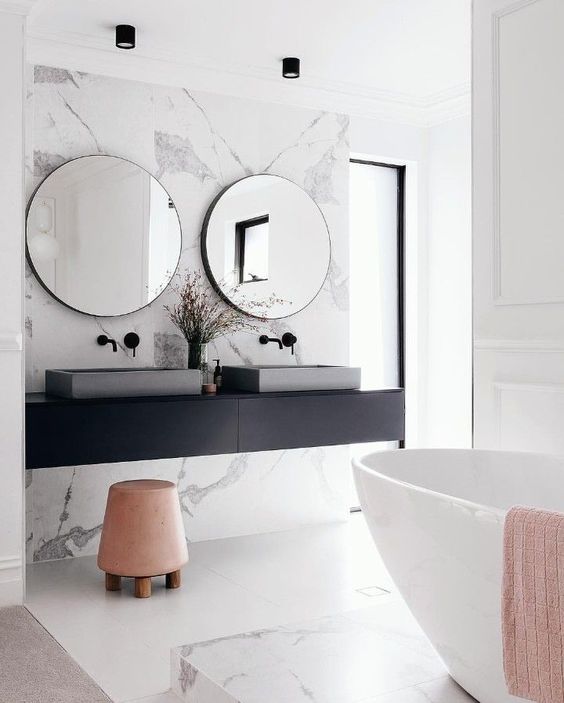 a gorgeous marble accent wall and bathtub platform make the space peaceful and refined
