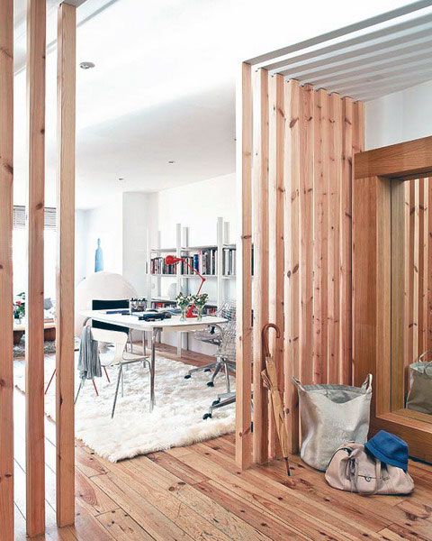 wooden plank screens on both sides divide the home office from the entryway