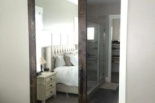 20 a dark stained barn door with a mirror insert hides a bathroom and a closet