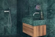 20 a minimalist bathroom fully covered with green marble tiles that are contrasting light-colored wood