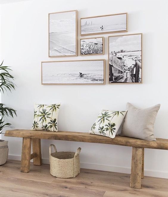 a natural space with a wooden bench and a black and white gallery wall with matching frames